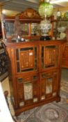 An Edwardian inlaid cabinet with bevelled mirror panels
