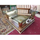 A large ormolu coffee table with glass top and recessed base.