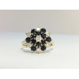 An 18ct gold diamond and sapphire cluster ring, hall marked H & M Birmingham 1954, size M.