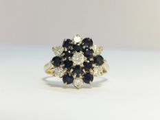 An 18ct gold diamond and sapphire cluster ring, hall marked H & M Birmingham 1954, size M.