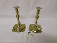 A pair of 19th century brass petal based candlesticks.