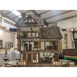 A large old style dolls house with furniture.