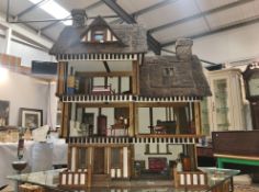 A large old style dolls house with furniture.