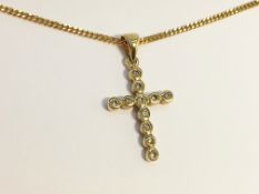 A gold and diamond cross on chain.