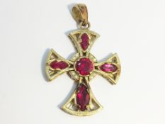 A 9ct gold cross in a gothic style set with red (possibly garnets) and white stones.