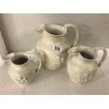 A set of 3 graduated Wedgwood creamware jugs embossed with cherubs and foliage.