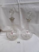 A pair of small Mary Gregory glass decanters.