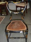 A 19th century lacquered chair with cane seat.
