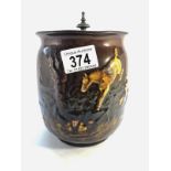 A Royal Doulton Kingsware brown biscuit jar with a picture in relief featuring horses,