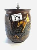 A Royal Doulton Kingsware brown biscuit jar with a picture in relief featuring horses,