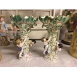 A pair of 19th century porcelain comports surmounted by cherubs. Approximate height 31.75cm.