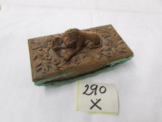 A carved wood desk blotter with carved lion atop.