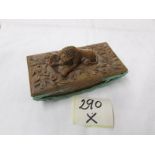 A carved wood desk blotter with carved lion atop.