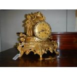 A gilded mantel clock surmounted figure.