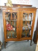An Edwardian mahogany display cabinet with fine shell and string inlay.