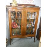 An Edwardian mahogany display cabinet with fine shell and string inlay.