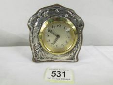 A silver fronted mantel clock.