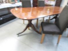 A double pedestal oval mahogany dining table with string inlay.