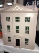 A 3 storey doll's house with fittings (no furniture).