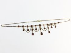 A 9ct gold garnet festoon necklace.