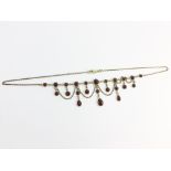 A 9ct gold garnet festoon necklace.