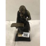 A bronze figure of a chimpanzee reading