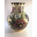 A Moorcroft bulbous vase hand painted by Irving featuring large stylised flowers on a white base