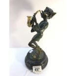 A bronze figure of a pixie playing a saxophone.