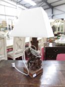 A carved black forest table lamp with shade.