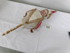 An antique bisque headed doll on stick.