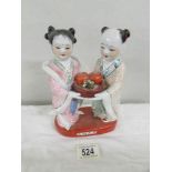 A Chinese figural group of 2 females with fruit bowl, approximately 20 cm tall.