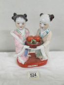 A Chinese figural group of 2 females with fruit bowl, approximately 20 cm tall.