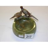 A pair of cold painted bronze pheasants surmounted on a heavy green onyx dish.