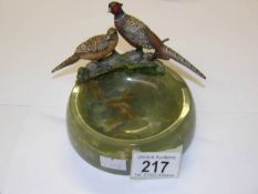 A pair of cold painted bronze pheasants surmounted on a heavy green onyx dish.