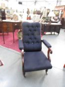 A Victorian mahogany adjustable arm chair with deep button back.