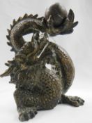 An old bronze dragon holding a ball.