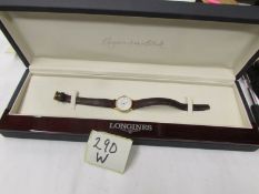 A Longines ladies wrist watch with 18 carat yellow gold face and brown leather strap.