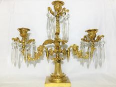 A gilded brass eagle surmounted candelabra with glass droppers