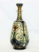 A Doulton Lambeth 1880 vase in subdued colours over a patterned green ground.