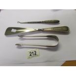 A silver handled button hook, a silver handled shoe horn and silver sugar tongs.