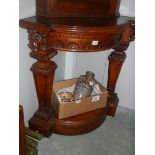 A mahogany corner stand with lion head carvings.