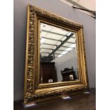An ornate gilt framed bevel edged mirror.