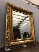 An ornate gilt framed bevel edged mirror.