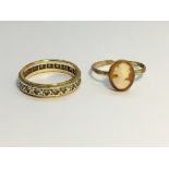 A 9ct gold and diamond eternity ring, size O and a 9ct gold shell cameo ring, size N.