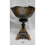 A Doulton Lambeth bowl on a pyramid shaped stand with a floral and leaf type pattern in greens,