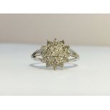 A 9ct white gold diamond cluster ring, size L.