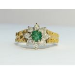 An 18ct yellow gold circular diamond ring with centre emerald, size K.