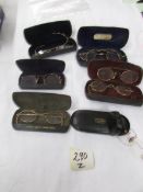 A quantity of vintage gold rimmed spectacles in cases.