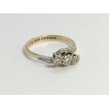 An 18ct 2.4 gram yellow gold 3 stone diamond cross over ring, size M.