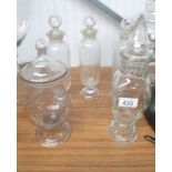 5 glass apothecary bottles.